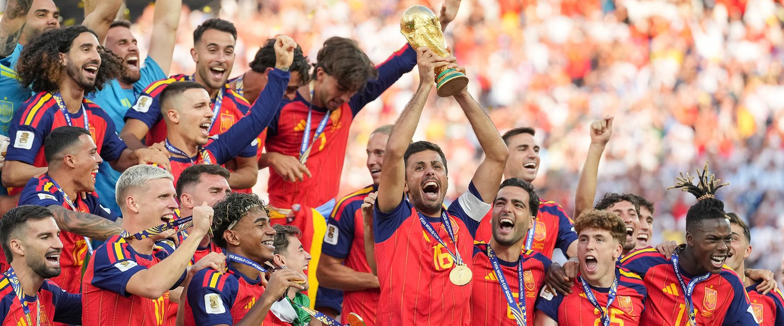 Celebración coral de la selección española alzando la Copa del Mundo entre gritos y abrazos en el campo